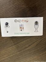 Photo of white box showing WiFi panorama camera with E27 base design, panoramic lens on top, and control features.