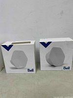 Two white Bell WiFi pods in separate retail boxes with blue design elements on top left corner, Bell branding on front.