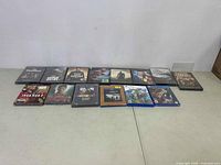 Full view of all DVD movies and video games in lot arranged in two rows on floor