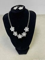 Full display of the necklace and earrings on a black velvet bust and earring stand showing overall design and proportions.