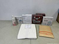 Full lot showing cat feeder dishes, French card games, white curtain panel, spray cleaner, NTBAY envelope.