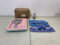 Lot arranged with four colorful pet litter trays stacked with gray litter scoop on top, pet odor neutralizing spray bottle, and purple dog harness still attached to packaging.