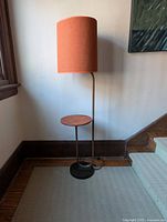 Full view of lamp with orange shade and side table