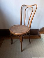 Front angle full view of the wooden bentwood café chair showing curved backrest and round veneered seat.