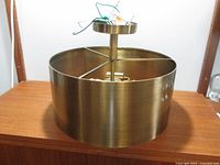 Front and side view of the cylindrical metal pendant light showing shade and wiring.