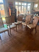 Six dining chairs—two with arms and four without—arranged in a room.