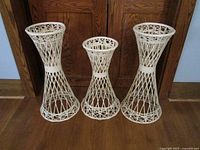 Front view showing three faux rattan plant holders arranged in a row.