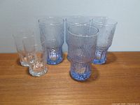Group photo showing all six glasses, four blue textured glasses with thick bases, two clear textured glasses with thick bases, arranged on table.