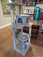 Full view of the multi-level cat tree showing base, platforms, enclosed box, and scratching posts.