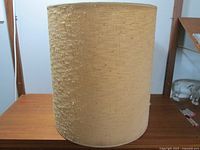 Side view of the large beige fabric over paper lamp shade showing texture and size