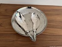 Top-down view of bowl with spoon and fork resting inside