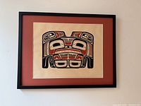 Full view of framed print mounted on wall, showing red mat and black metal frame