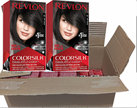 Open cardboard box containing 12 sealed Revlon Colorsilk Beautiful Color hair dye boxes showing front design with #11 Soft Black shade and product features.