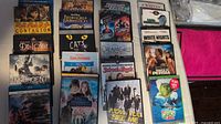 Top view of arranged DVD and Blu-ray cases, showing titles such as Contagion, The Boondock Saints, and Cats.