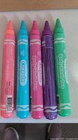 Close-up photo of five Crayola Body Wash Soap Pens in pink, blue, purple, green, and orange colors.