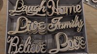 Photo of six wooden inspirational words: Laugh, Home, Live, Family, Believe, and Love.