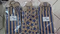Three packs of kraft paper gift bags with twisted handles. Two packs with blue and brown vertical stripes, one pack with blue star pattern on kraft paper. All bags in original sealed plastic packaging.