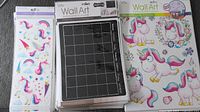 Stack of assorted stickers and chalk calendar pages showing black chalk calendar page and unicorn stickers.