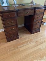 Front view of full desk showing seven drawers and brass handles