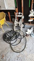 Full shot of hose caddy reel with coiled hose on floor