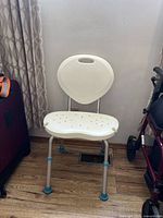 Full view of the Aqua Sense tub chair with handle on backrest, white plastic seat with drainage holes and adjustable legs.