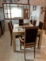 Dining table with mirror inlay and six chairs in a kitchen dining area.