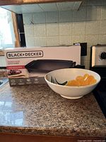 Electric griddle box and ceramic serving bowl on kitchen counter