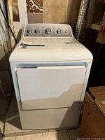 Front view of the white dryer showing door, control panel and overall condition