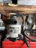 Shop-Vac 4 gallon wet/dry vacuum unit without hose attached, showing front label and caster wheels.