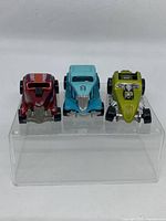 Three Hot Wheels hot rod cars front view, showing grill details, paint colors red, light blue, and green