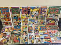 Lot of 13 vintage Archie Comics shown on flat surface, displaying colorful illustrated covers with various characters in classic cartoon style.