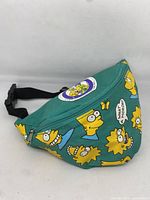 Front side view of green fanny pack with Bart and Lisa Simpson faces and circular Simpsons family patch