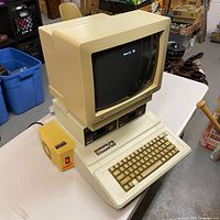Angled right view of computer, monitor, drives, and fan on table