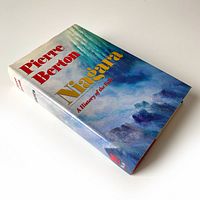 Image showing the front perspective of the hardcover book with dust jacket titled 'Niagara: A History of the Falls' by Pierre Berton, featuring a colorful illustration of Niagara Falls.
