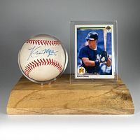 Signed baseball and Upper Deck card displayed on a wooden stand.