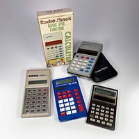 Four vintage calculators displayed: Radio Shack EC-221 with original box and case, Texas Instruments TI-108, Sanyo CX-2520, and Sharp EC-211.