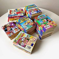 Collection of 56 digest-size Archie Comics collection stacked on a table, includes various titles like Archie Jumbo Comics, Archie Giant Comics, Betty & Veronica, and Jughead.