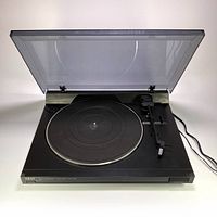 Full view of the Akai AP-A150 turntable with transparent dust cover open, showing platter, tonearm and control details.