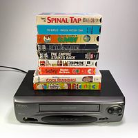 Citizen JVHS3968 VCR unit with nine stacked VHS tapes showing their titles.