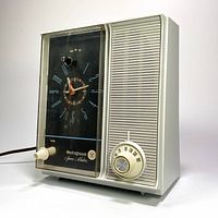 Side angled view of vintage Westinghouse clock radio showcasing the clock face on the left and speaker grille with tuning dial on the right.