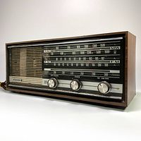 Left front angled view of the vintage Grundig radio showing the wood grain cabinet and control knobs.