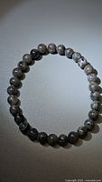 Yooperlite bead bracelet laid flat, showing full circle of round stone beads under neutral light.