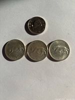 Four Canadian Centennial coins. Three show a cougar and one shows a rabbit, all dated 1967 on one side.