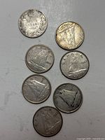 Top view showing reverse sides of seven Canadian dimes with Bluenose schooner design and various dates.