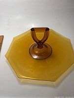 Top view of the octagonal amber glass sandwich tray showing the central solid handle for carrying.