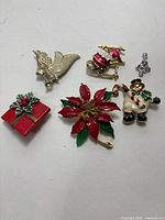 Top view of the Christmas jewelry pins and pendant arranged on white background showing color and details