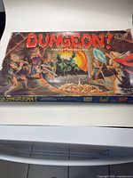 Photo of the Dungeon! Fantasy board game box with fantasy artwork of adventurers and dragon.