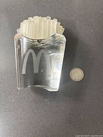 Crystal McDonald's fries award shown from an angle with quarter coin