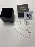 Murano glass bubble pendant necklace on silver chain with spring ring clasp alongside black textured De Biasi box and tag.