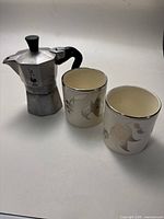 Photo showing the Moka pot with two decorative lusterware cups
